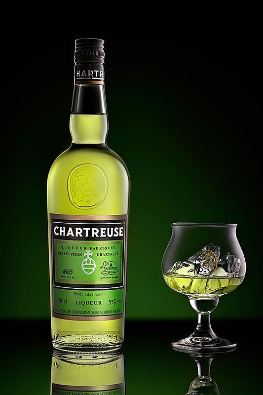Photographie d'une bouteille de Chartreuse verte et de son verre de dégustation
